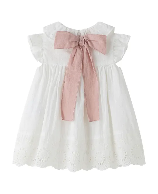 White ruffled baby dress with pink bow at neckline