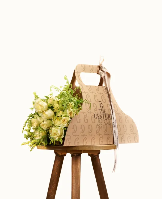 Wooden cutting board with handle hanging on stand with yellow flowers