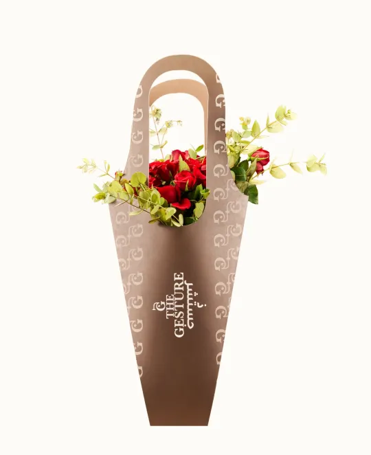 Brown ceramic vase with handles and floral arrangement