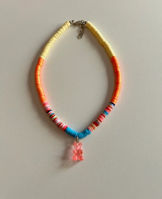 Beaded necklace with orange, yellow, and blue sections and pink shell pendant