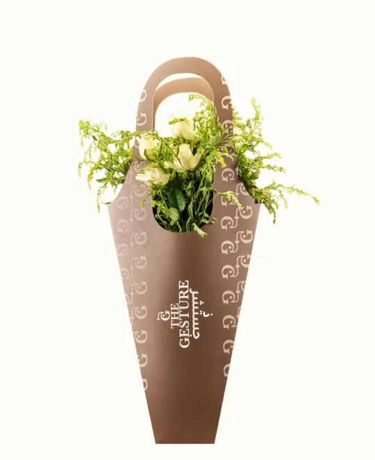 Brown tapered planter with handles filled with yellow and green flowers