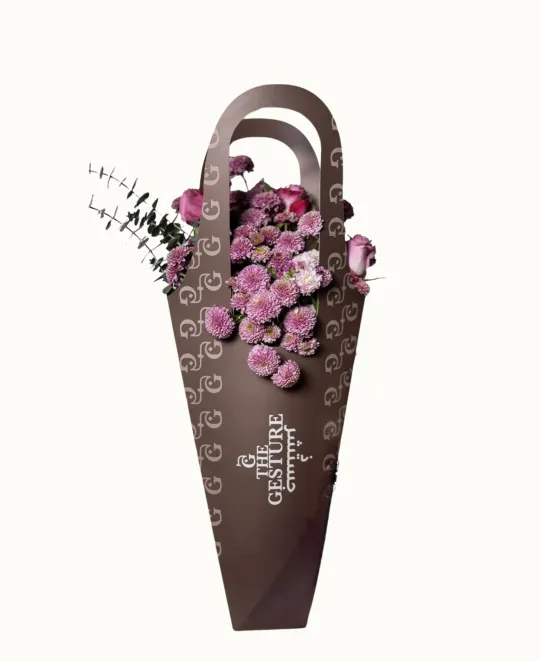 Dark wicker cone-shaped wall basket with purple flowers and decorative handles