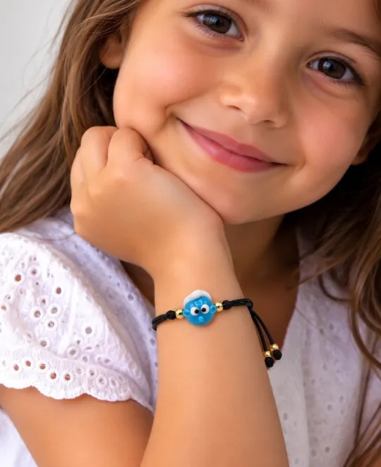 Young girl wearing blue beaded bracelet with eye charm detail
