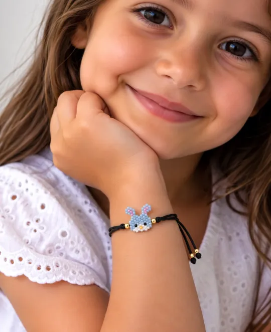 Young girl wearing a beaded bracelet with colorful charms on her wrist
