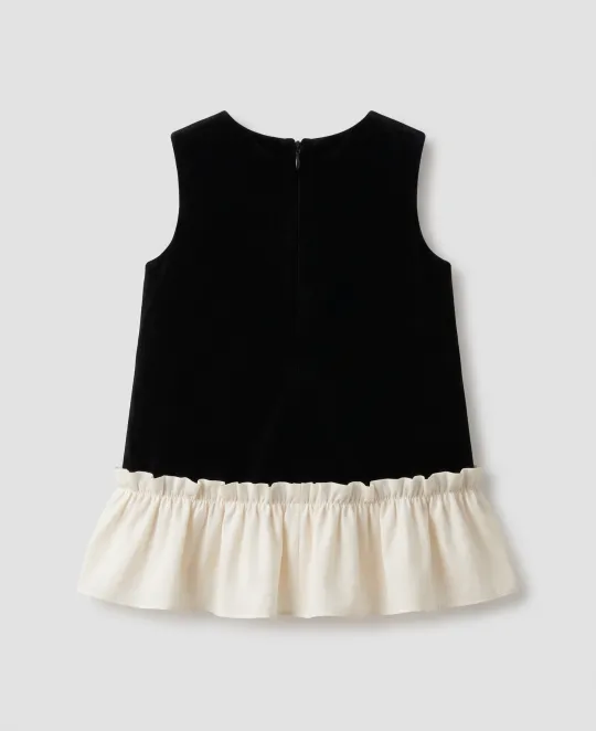 Black sleeveless top with cream-colored ruffled hem