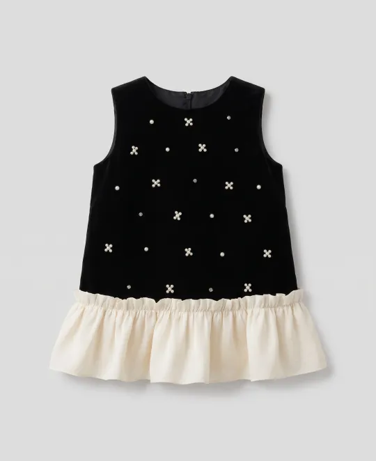 Black sleeveless top with star embroidery and cream ruffle hem