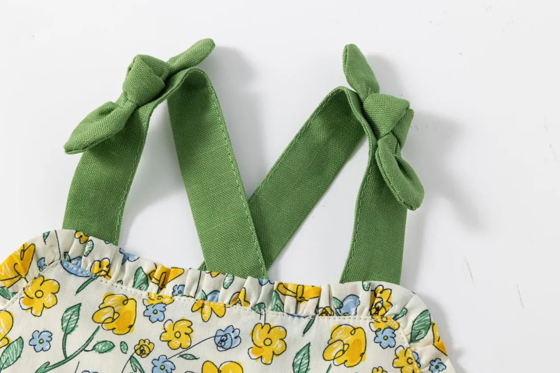 White dress with yellow sunflower print and green shoulder ties