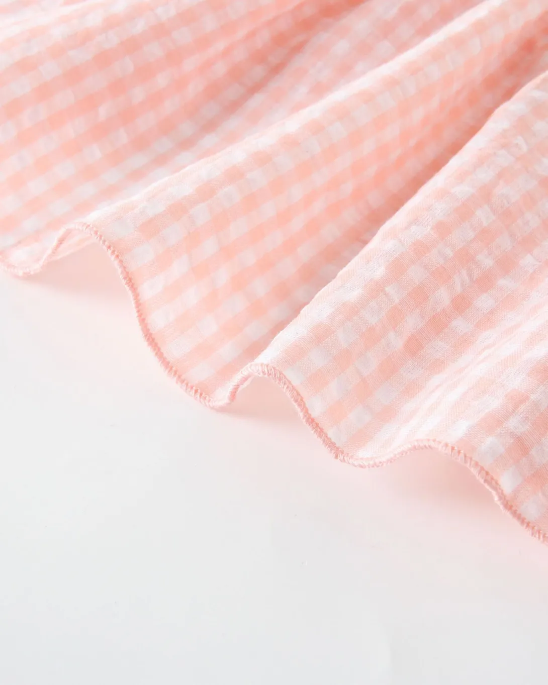 Pink gingham textured fabric with ruffled edge