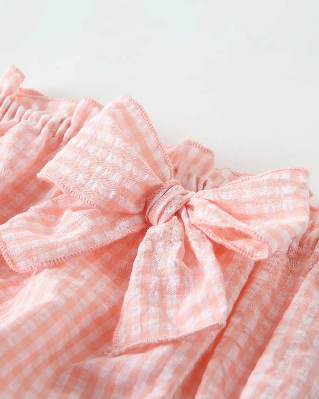 Pink and white gingham fabric with gathered elastic waistband and bow detail