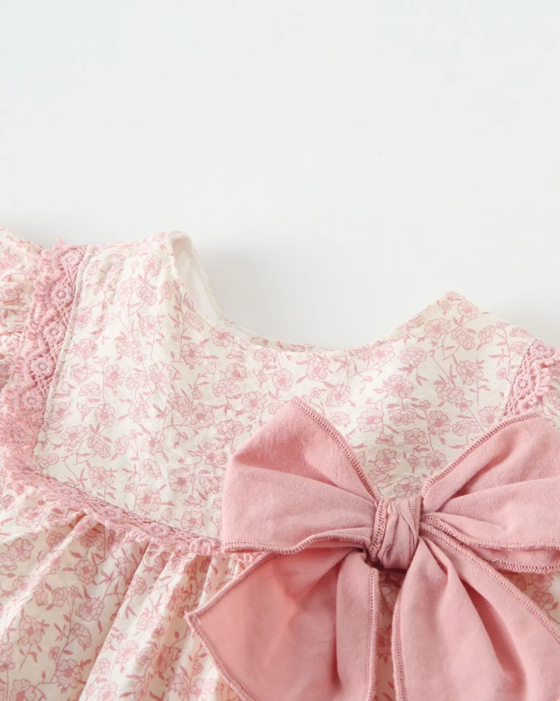 Pink sequined garment with pink satin bow detail at waist