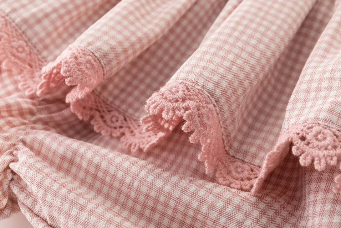 Pink and white gingham fabric with scalloped lace trim edges