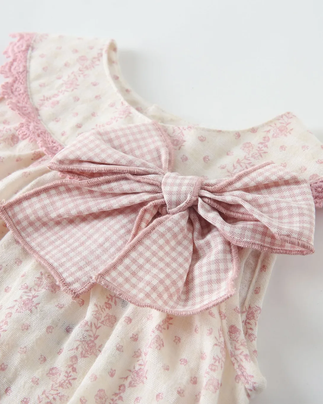 Pink and white gingham romper with bow detail at waist