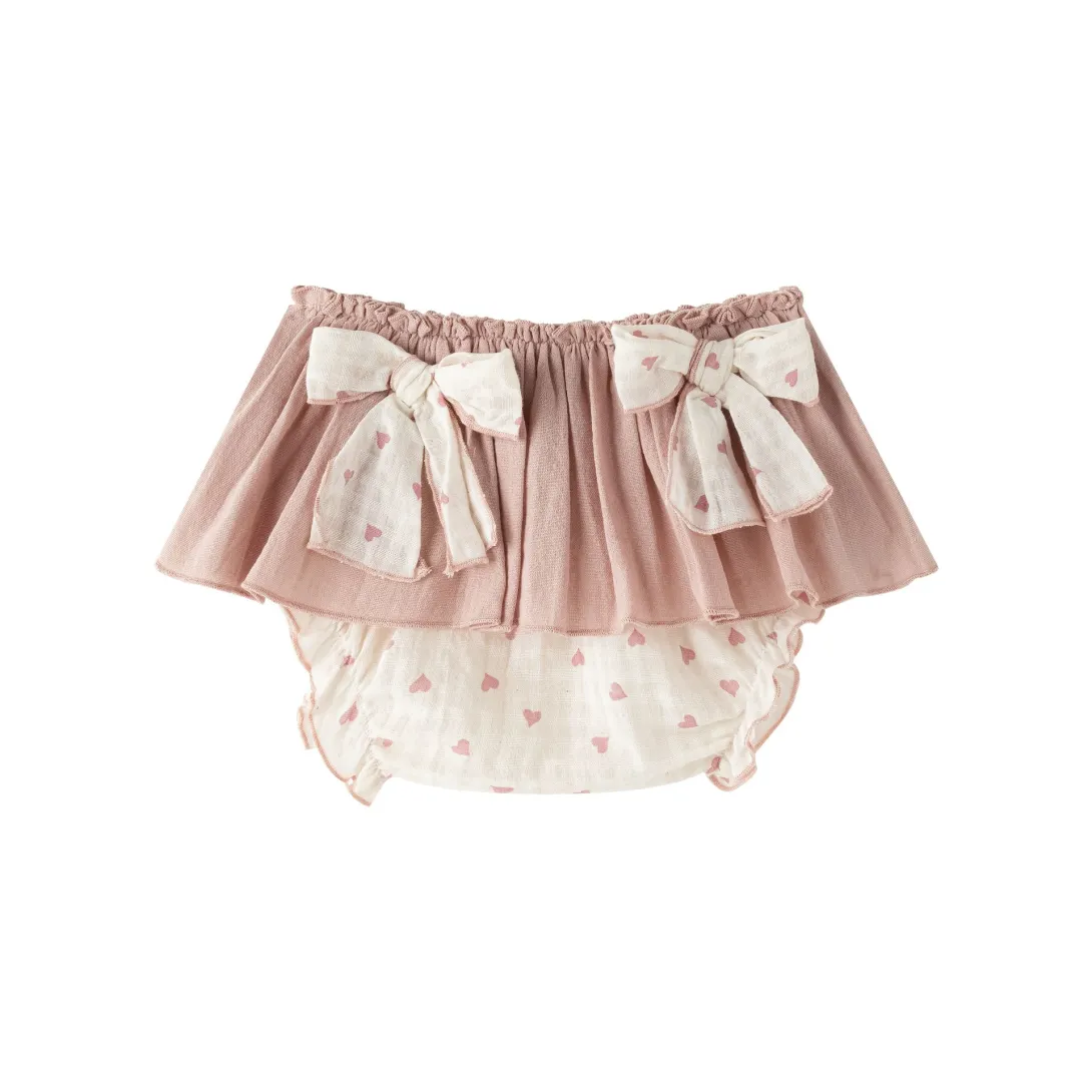 Pink ruffled bloomer with white lace trim and bow details