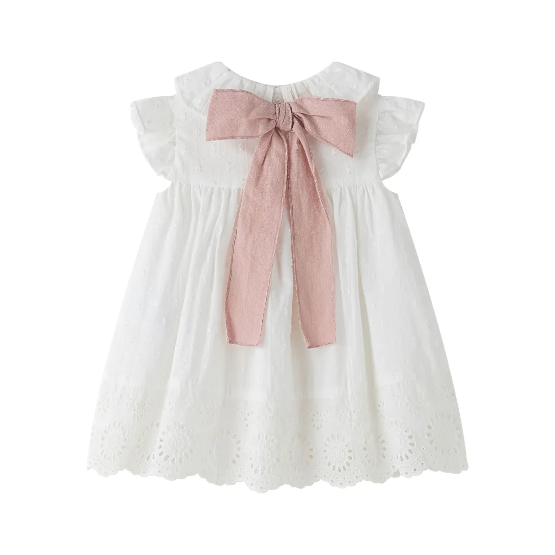 White ruffled baby dress with pink bow at neckline