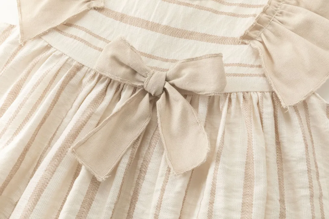 Cream-colored gathered fabric with small bow detail at waistband