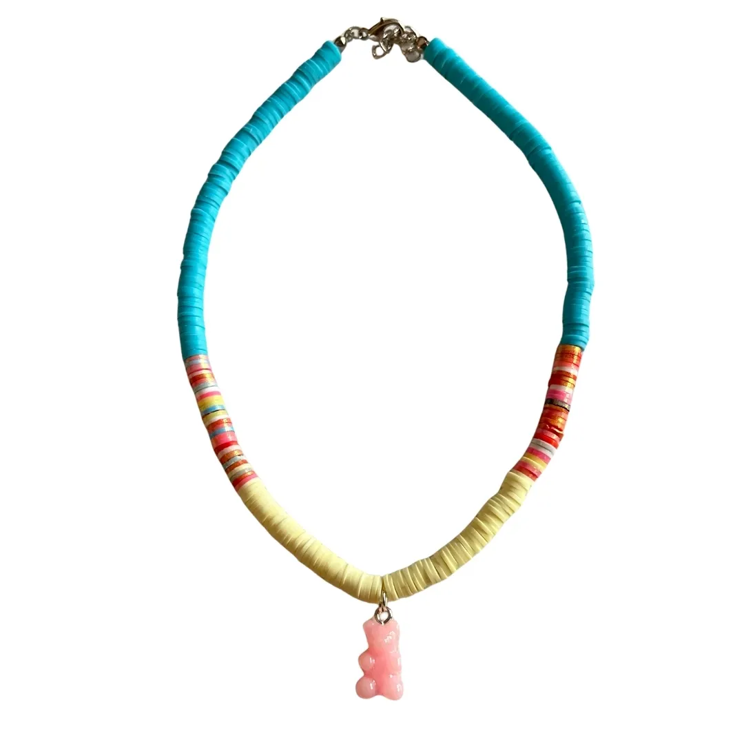 Beaded necklace with turquoise, coral, and cream colored beads and pink tassel pendant