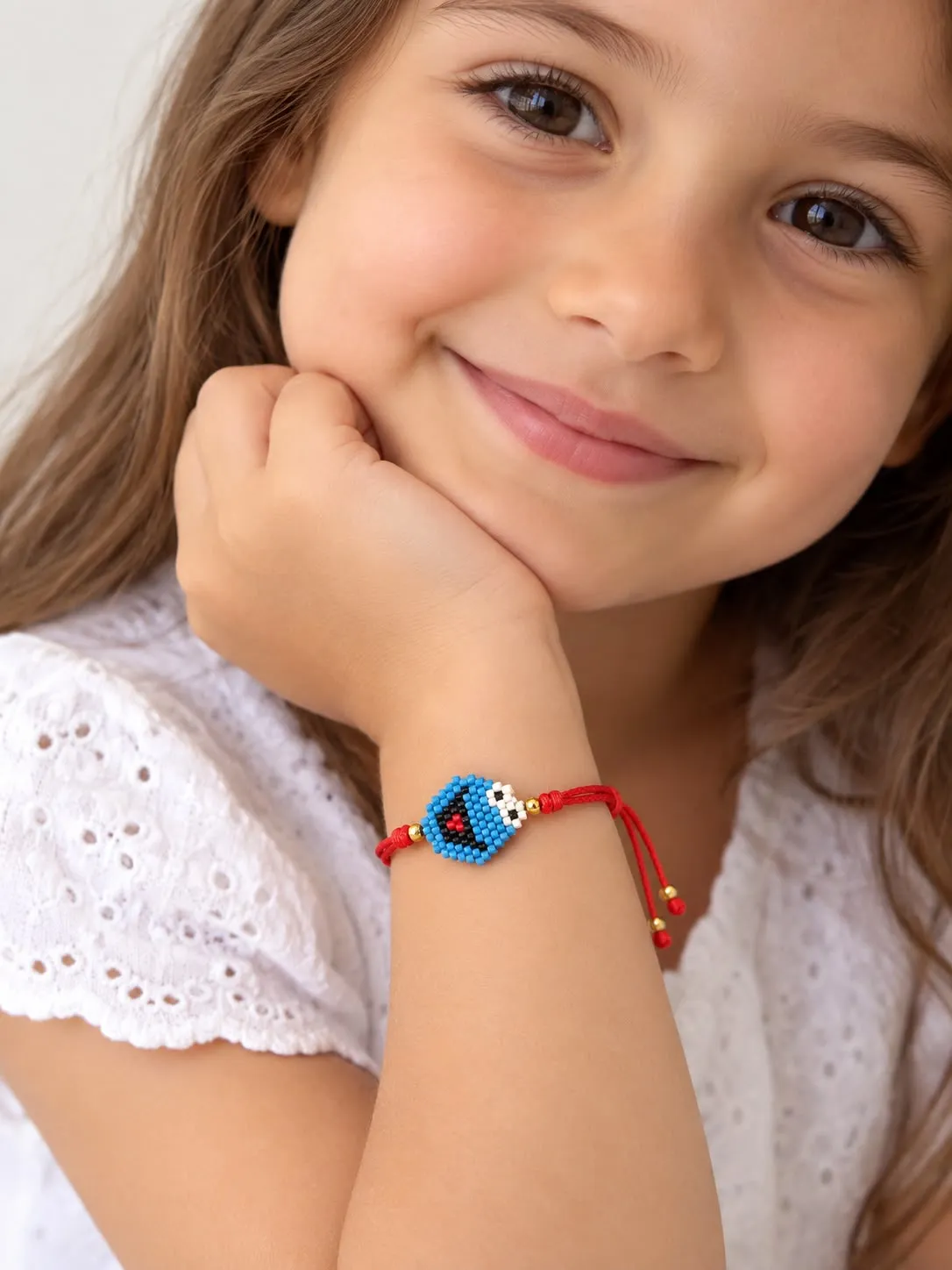 Girl wearing colorful beaded bracelet with blue center bead on wrist