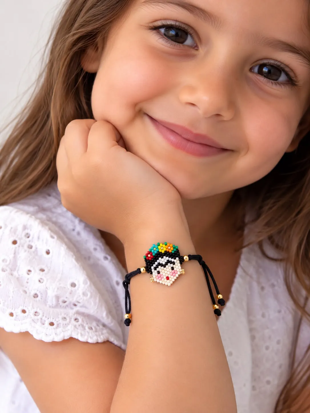 Young girl wearing a beaded bracelet with a small flower charm