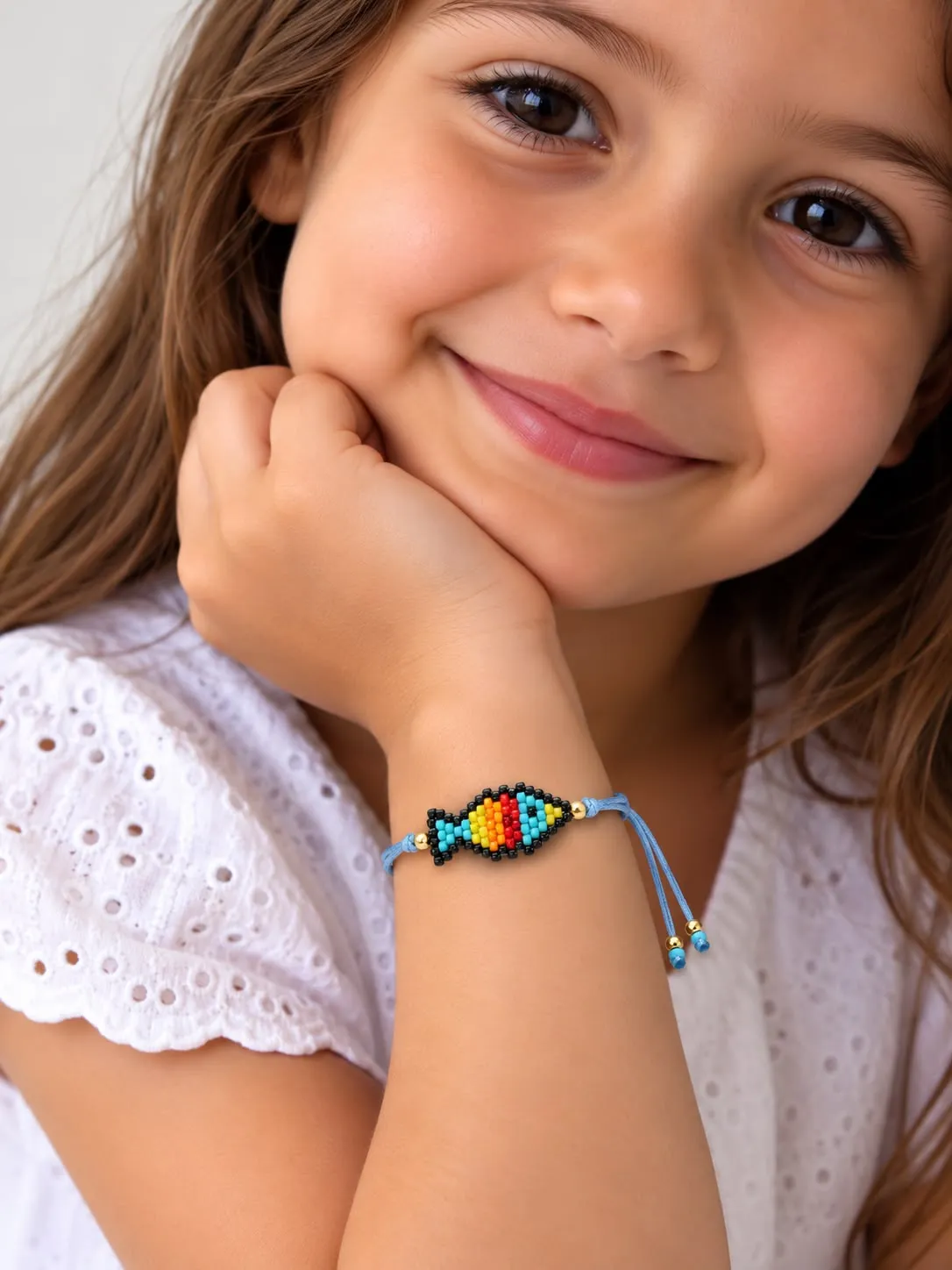 Young girl wearing a beaded bracelet with colorful heart charm
