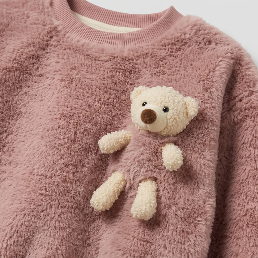 Pink fuzzy sweater with cream teddy bear appliqué on chest